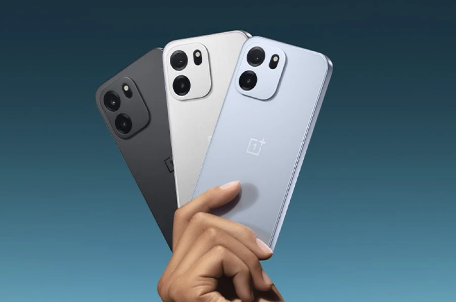 Uma mão segura três OnePlus N6, exibindo o design traseiro do e três opções de cores: preto-fosco, prata e azul-claro.
